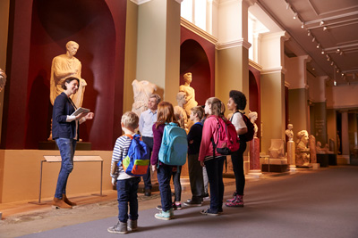 museum tour guide showing students around worthwhile TLDs