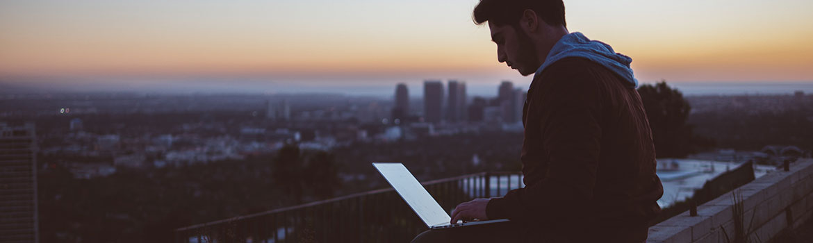 man looking at laptop pondering the .com price cap